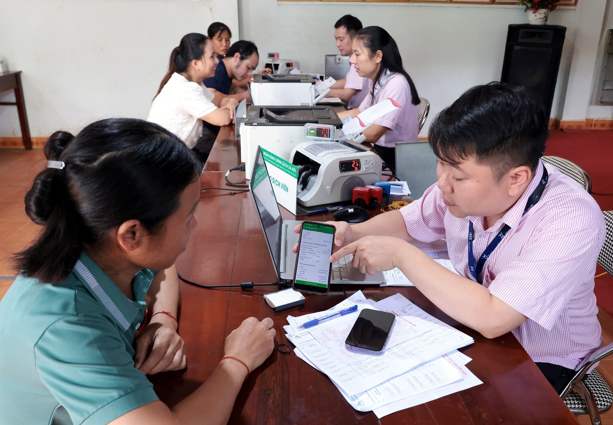 Tổ trưởng Tổ Tiết kiệm và vay vốn sử dụng phần mềm trên điện thoại để giao dịch tại điểm giao dịch xã Bản Lầu, Lào Cai. (Ảnh: Trần Việt/TTXVN)